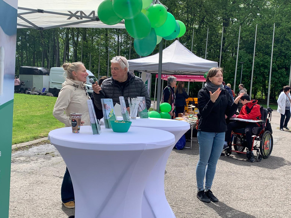 Gesine Schröter wird am Stand des Sozialen Förderwerkes vom Moderator der Veranstaltung interviewt. Eine Gebärdensprachdolmetscherin übersetzt das Gesagte.